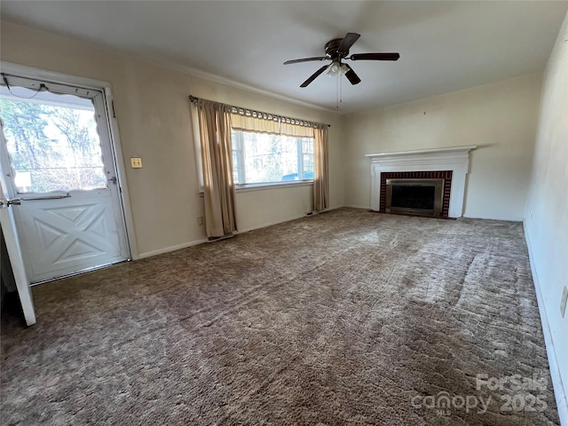 unfurnished living room with a brick fireplace, ceiling fan, and dark colored carpet