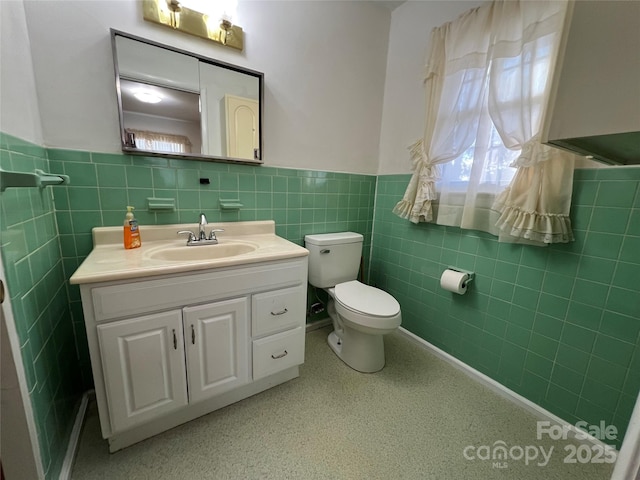 bathroom featuring vanity, tile walls, and toilet