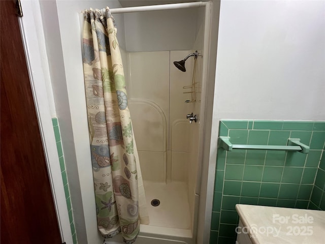 bathroom featuring tile walls and a shower with shower curtain