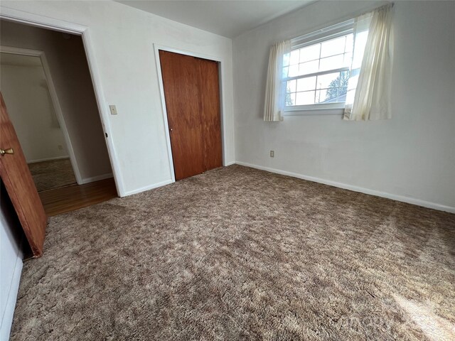 unfurnished bedroom featuring carpet and a closet