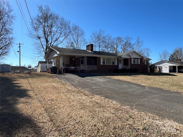 single story home with a front yard and a carport