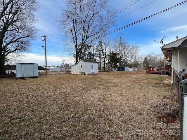 view of yard featuring cooling unit, a deck, and a shed