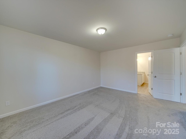 unfurnished bedroom with ensuite bathroom and light colored carpet