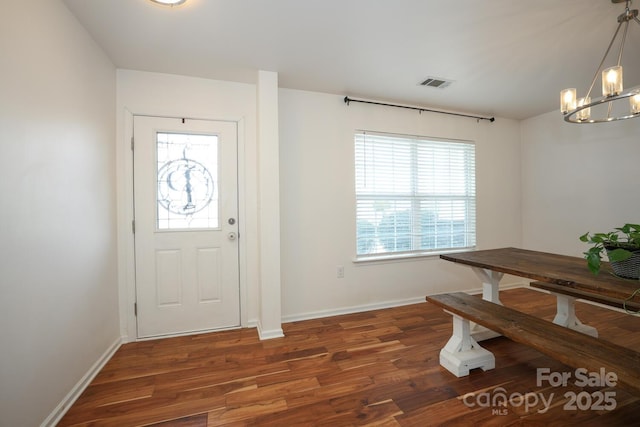 foyer featuring dark hardwood / wood-style floors and a chandelier