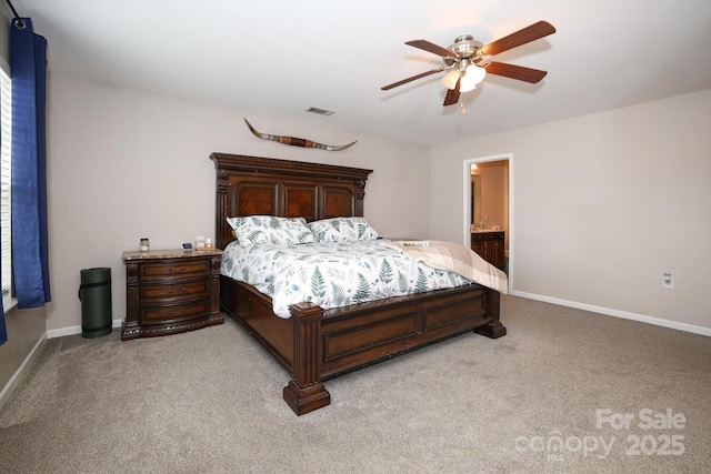 bedroom featuring light carpet, ceiling fan, and ensuite bath