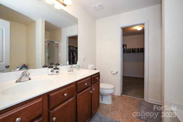 bathroom featuring vanity, an enclosed shower, and toilet