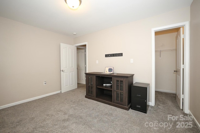 unfurnished bedroom with a walk in closet, light colored carpet, and a closet