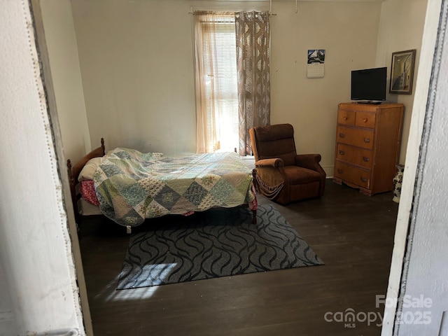 bedroom with dark hardwood / wood-style flooring