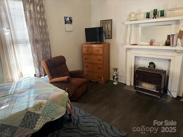 bedroom with a fireplace and dark wood-type flooring