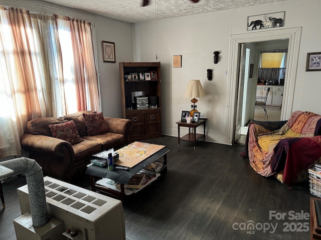 living room with dark wood-type flooring and a textured ceiling