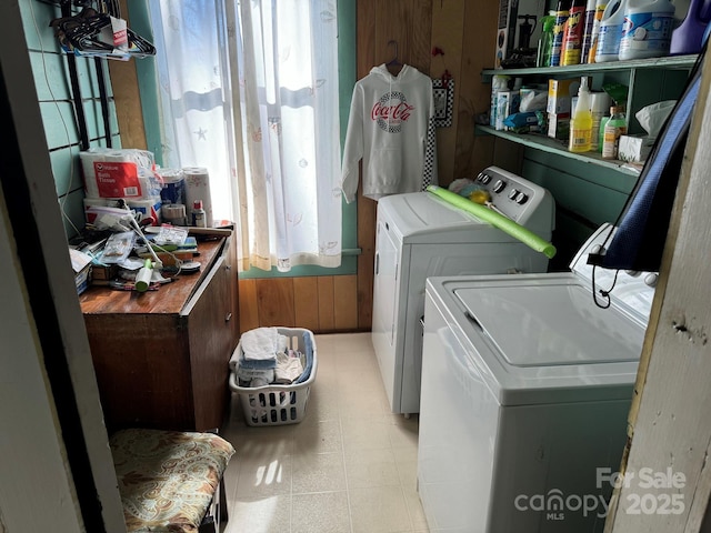 washroom featuring wooden walls and washer and clothes dryer