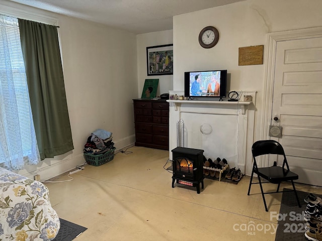 living room featuring concrete flooring and a wood stove