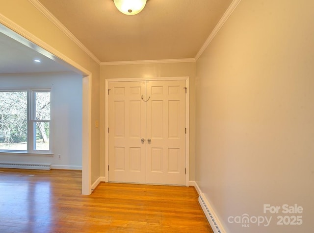 interior space with ornamental molding, light hardwood / wood-style floors, and a baseboard radiator