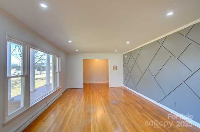 empty room featuring crown molding, a baseboard radiator, and light hardwood / wood-style floors