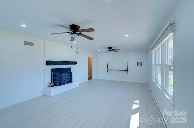 unfurnished living room featuring plenty of natural light and light hardwood / wood-style flooring