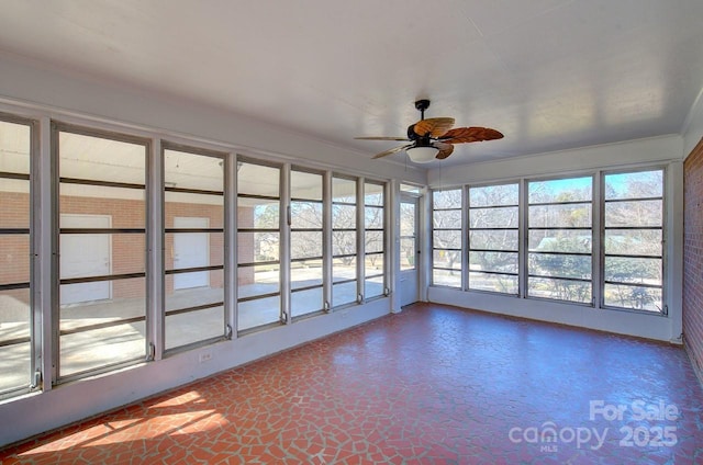 unfurnished sunroom with ceiling fan