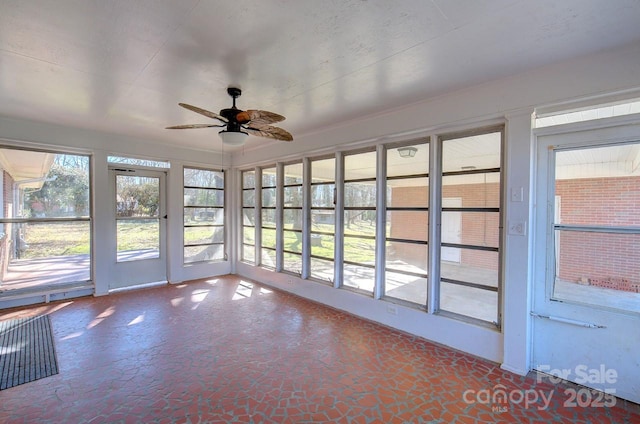 unfurnished sunroom with ceiling fan