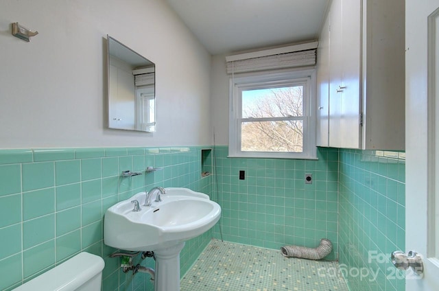 bathroom with tile walls, tile patterned flooring, and toilet