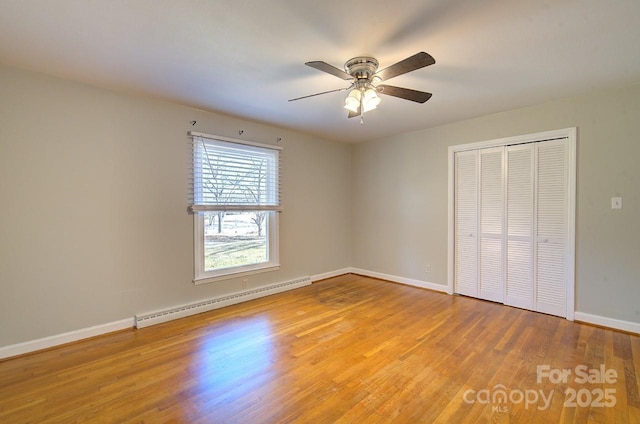 unfurnished bedroom with ceiling fan, a baseboard radiator, a closet, and light wood-type flooring