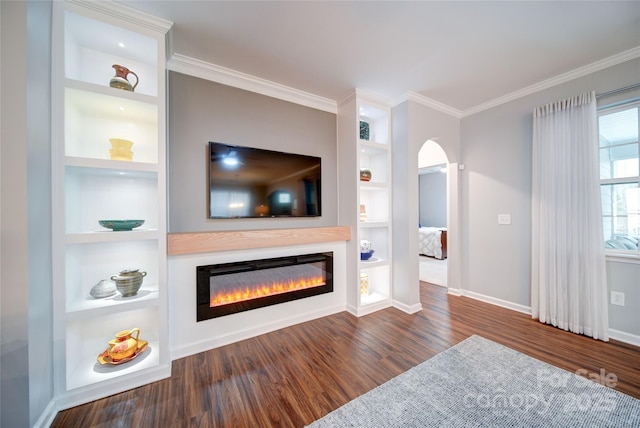 living room featuring dark hardwood / wood-style flooring, crown molding, and built in features