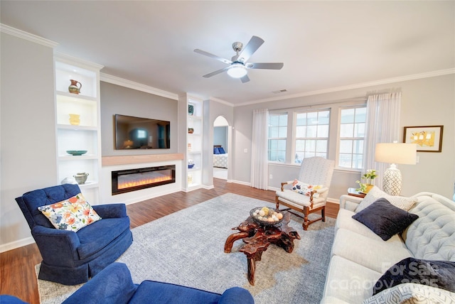 living room featuring crown molding, hardwood / wood-style floors, built in features, and ceiling fan