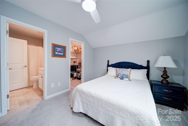 carpeted bedroom with lofted ceiling, ensuite bath, ceiling fan, a spacious closet, and a closet