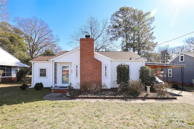 rear view of house featuring a carport and a yard