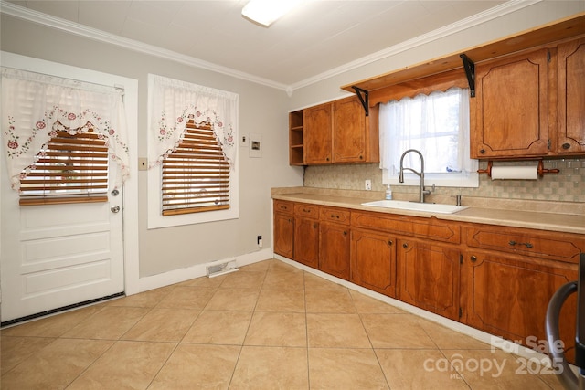 kitchen featuring ornamental molding, sink, light tile patterned flooring, and backsplash