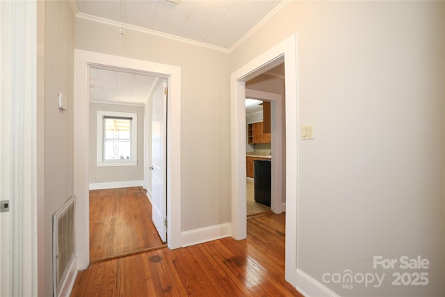 hall featuring ornamental molding and wood-type flooring