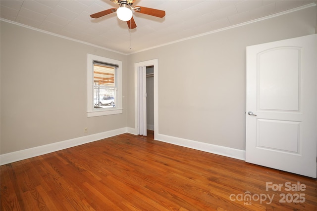 empty room featuring ornamental molding, hardwood / wood-style floors, and ceiling fan