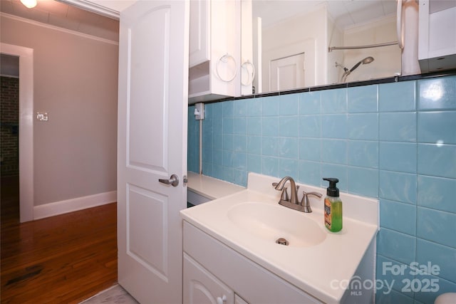 bathroom featuring vanity, crown molding, tile walls, and hardwood / wood-style flooring