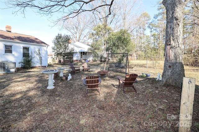 view of yard with central AC and a fire pit