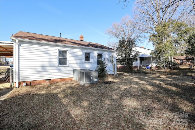 rear view of property featuring a yard and central air condition unit