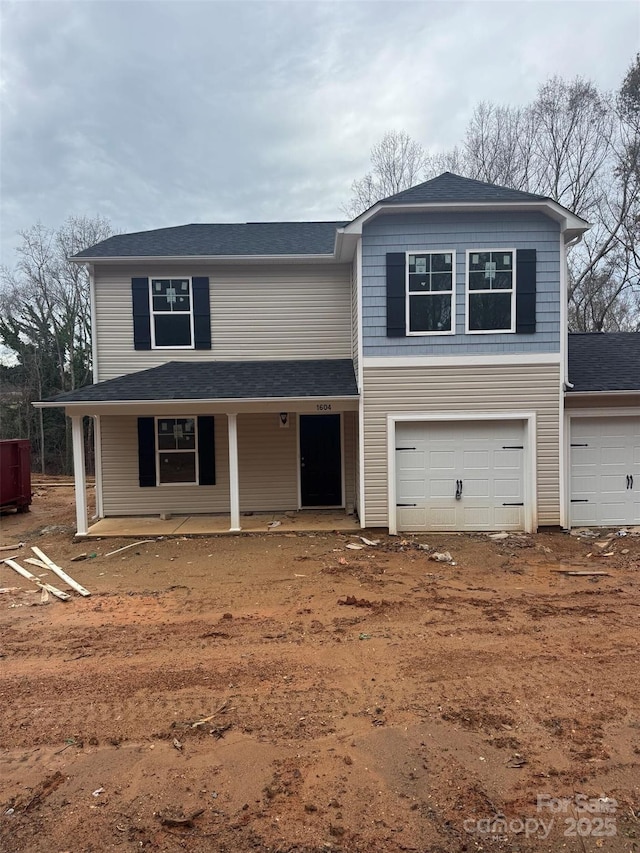 view of front property with a porch and a garage