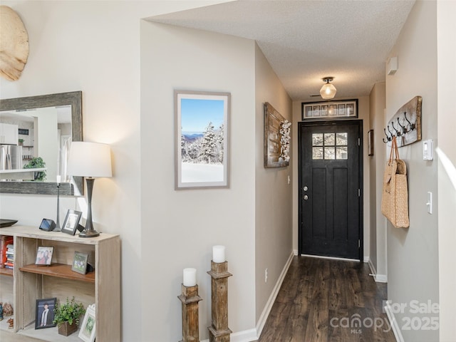 foyer entrance with dark hardwood / wood-style flooring and a textured ceiling