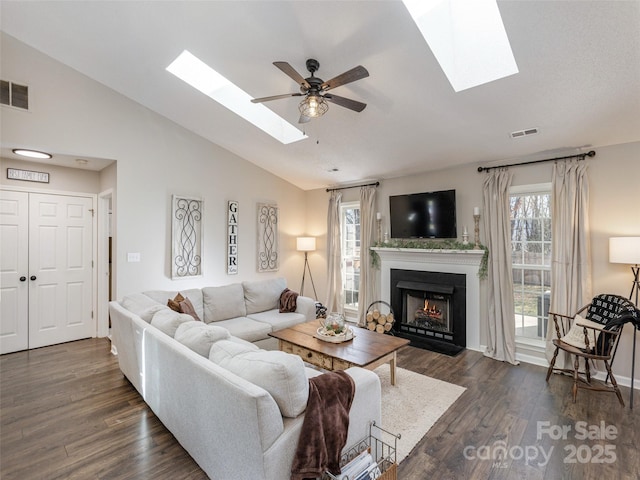 living area featuring a lit fireplace, vaulted ceiling, visible vents, and dark wood finished floors