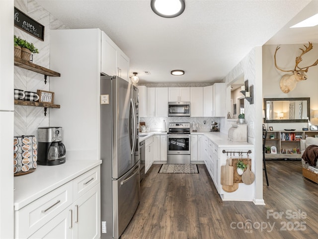 kitchen with appliances with stainless steel finishes, white cabinets, light countertops, and open shelves