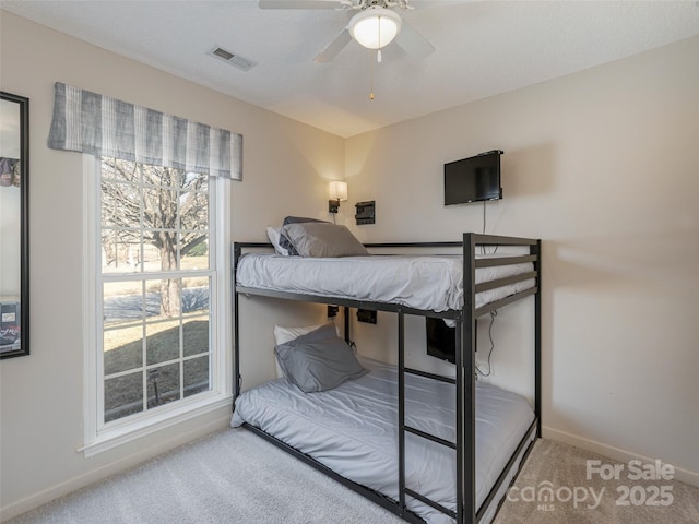 bedroom featuring carpet floors, visible vents, baseboards, and a ceiling fan