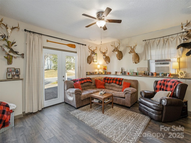 living room featuring ceiling fan, a textured ceiling, dark hardwood / wood-style flooring, and french doors