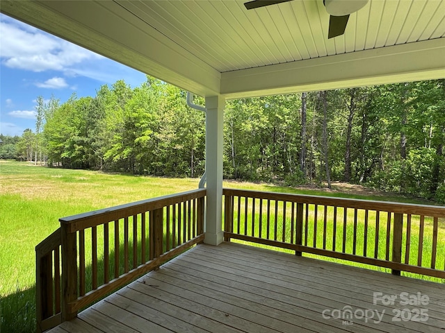 wooden deck featuring ceiling fan and a yard