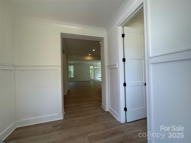 hallway with dark wood-type flooring and a decorative wall