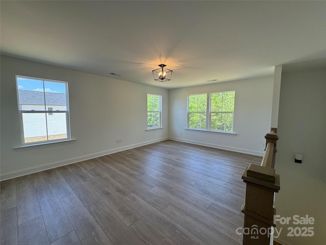 unfurnished room featuring visible vents, baseboards, and dark wood-style floors