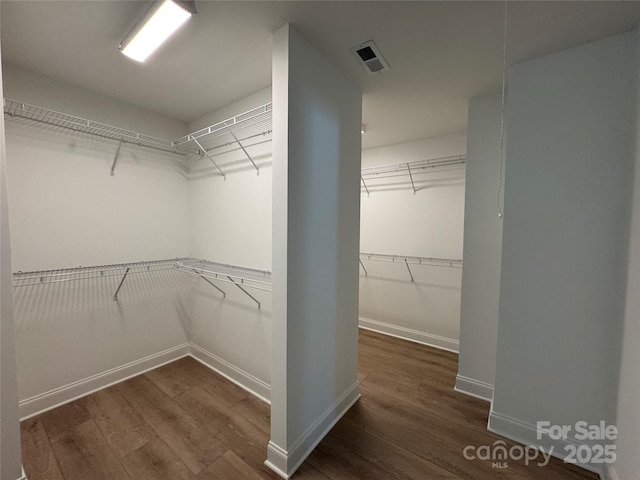 walk in closet with visible vents and wood finished floors