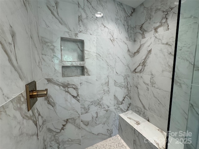 bathroom featuring a marble finish shower