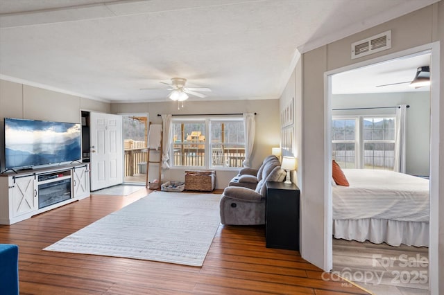 living room with hardwood / wood-style floors, crown molding, and ceiling fan