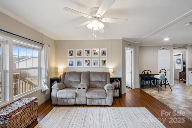 living room featuring hardwood / wood-style floors, ornamental molding, and ceiling fan