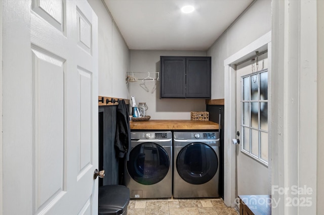 clothes washing area featuring washer and clothes dryer and cabinets