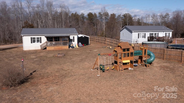 back of house featuring a fenced in pool and a playground