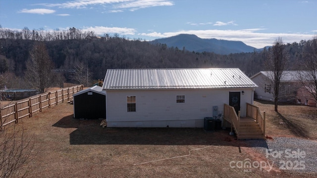 rear view of property with a mountain view and central AC