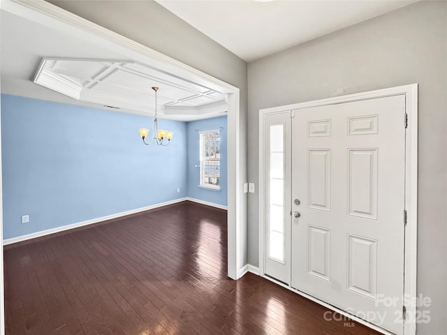 entrance foyer featuring dark hardwood / wood-style flooring and an inviting chandelier